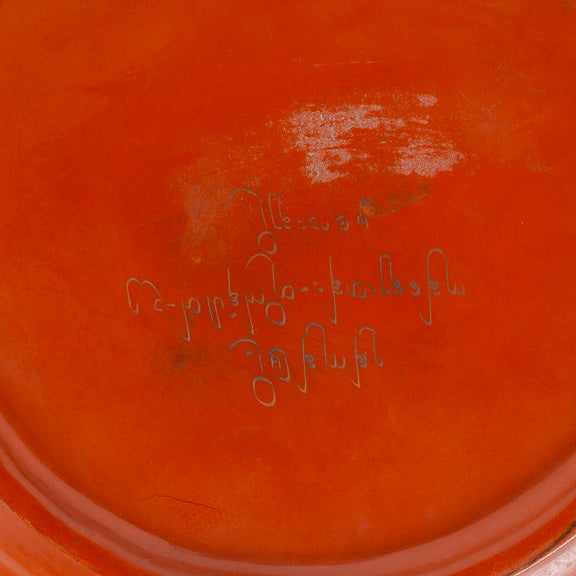 Red lacquerware dish with yellow painted flower, close up of back