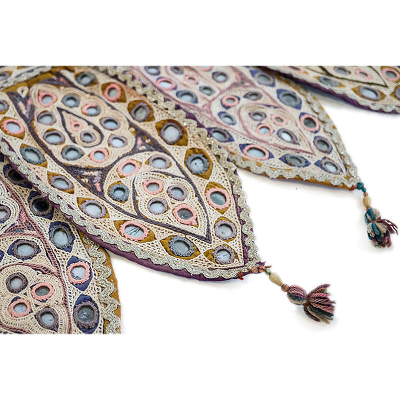 Colorful Indian door hanging with pieces of mirror, multicolored embroidery and tassels. Close up