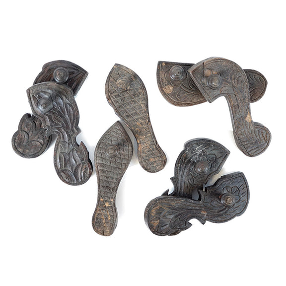 Four pairs of wood carved in a shoe shape with hand carved designs, top view