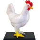 White rooster figurine with red comb on a black base against a white background