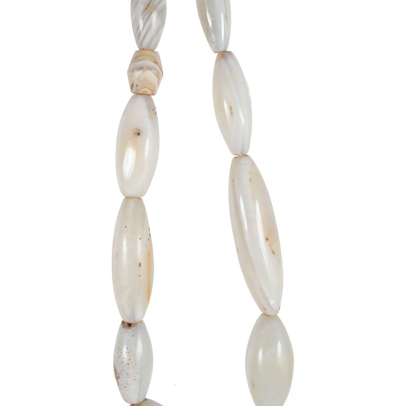 A strand of oval shaped white agate beads