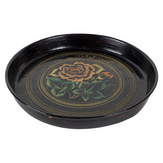 Black lacquerware dish with painted orange and green flower, side view