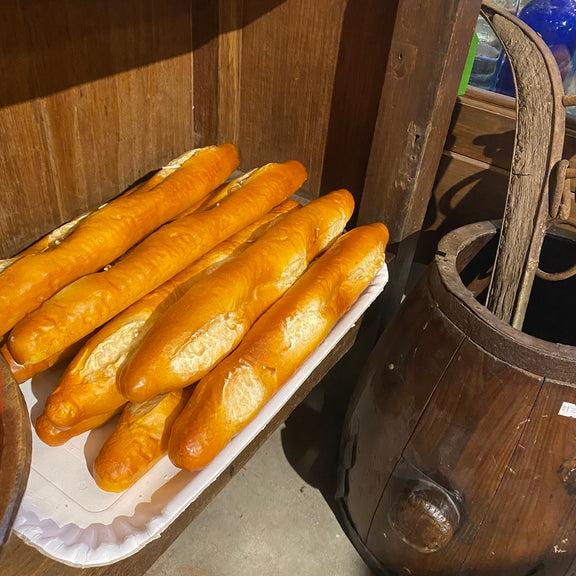 Baguette candles on a tray with a wooden barrel in the background
