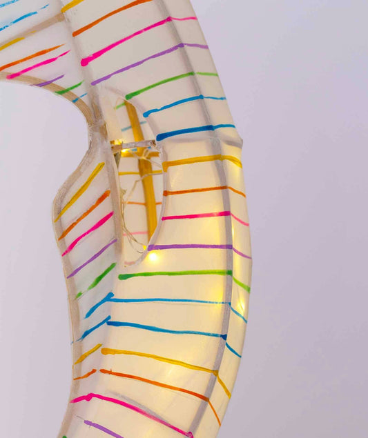 Necklace with colorful striped pattern on a light gray background