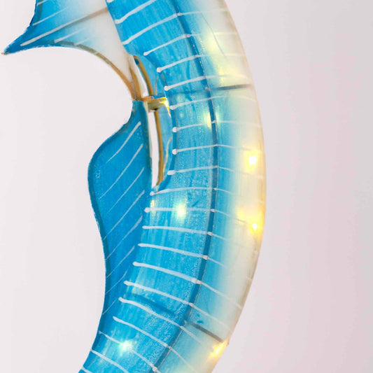 Decorative wall piece with blue and gold design on a light pink background