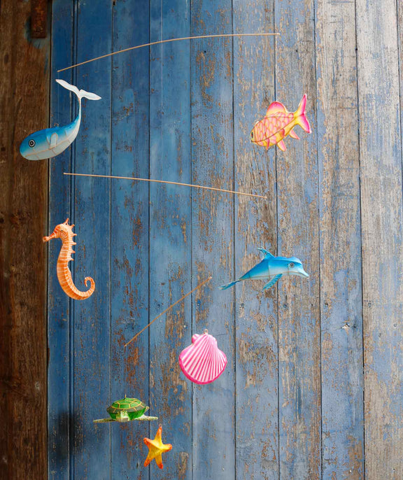 Decorative mobile with sea-themed figurines on a wooden surface