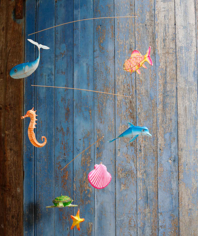 Decorative mobile with sea-themed figurines on a wooden surface
