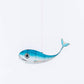Blue whale-shaped object hanging against a white background