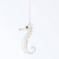 White seahorse ornament hanging on a white background