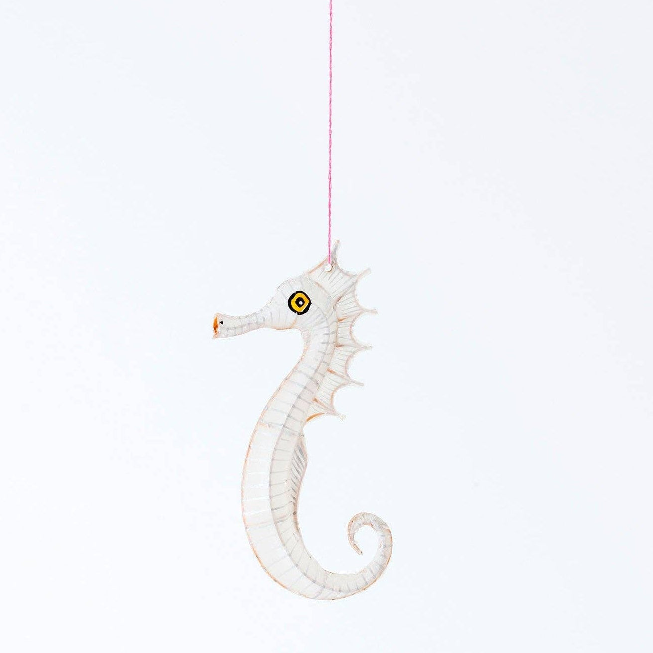White seahorse ornament hanging on a white background