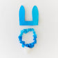 Blue bunny ears and scrunchie set on a white background