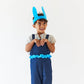 Child wearing blue overalls with bunny ears on a white background