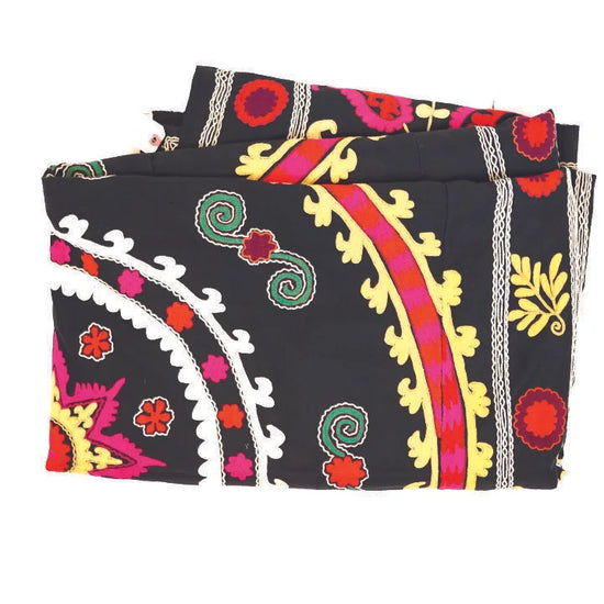 Colorful embroidered fabric with intricate patterns on a black background