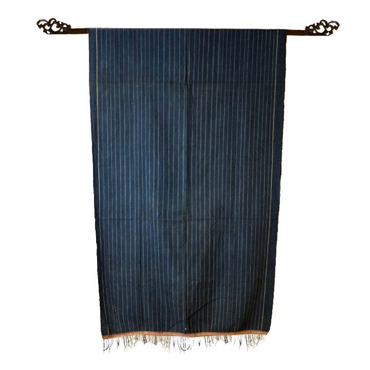 Cotton indigo colored batak with subtle stripe pattern, orange trim and black tassels