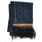 Cotton indigo colored batak with subtle stripe pattern, orange trim and black tassels. Folded