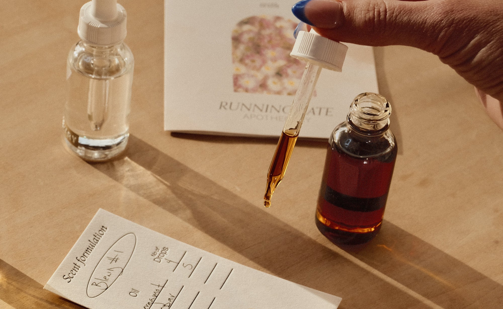 Small bottle with dropper, notebook, and notes on wooden surface