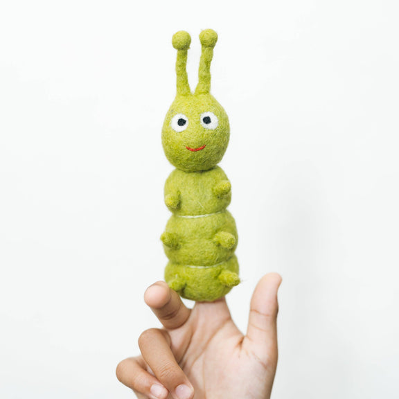 Green caterpillar finger puppet on a person's finger against a white background