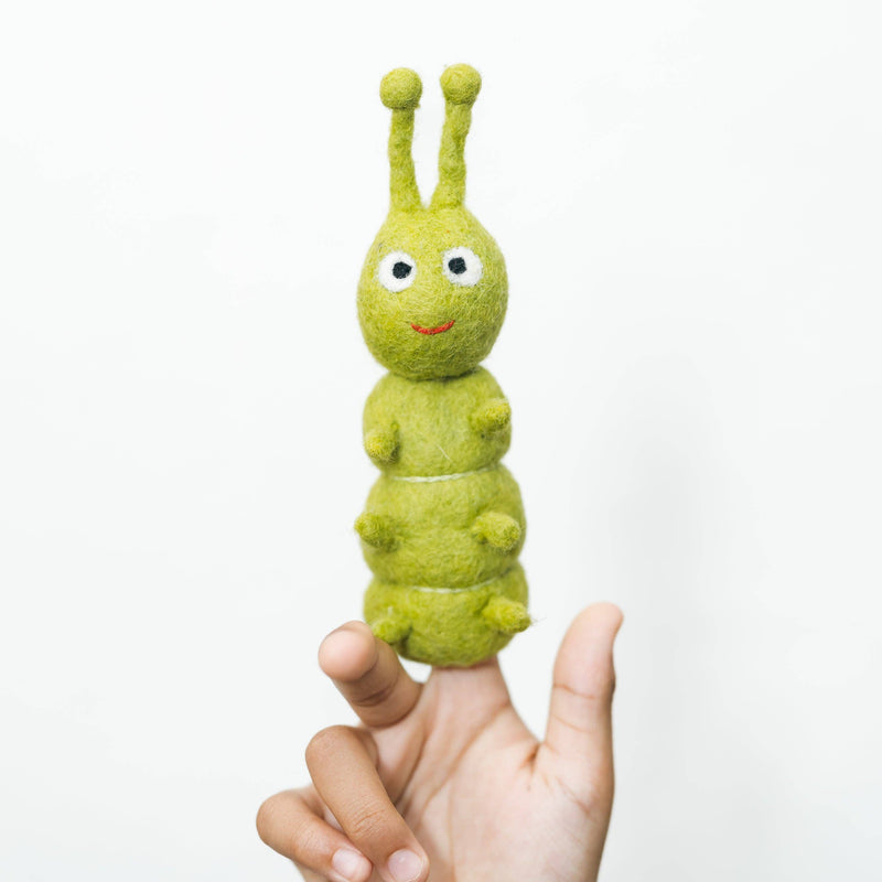 Green caterpillar finger puppet on a person's finger against a white background
