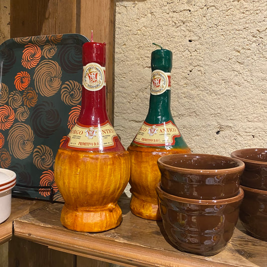 Decorative bottles and pots on a wooden surface with a textured wall background