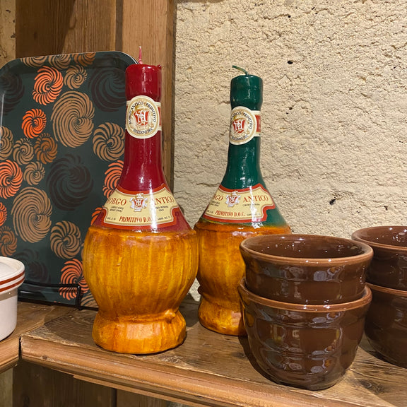 Decorative bottles and pots on a wooden surface with a textured wall background