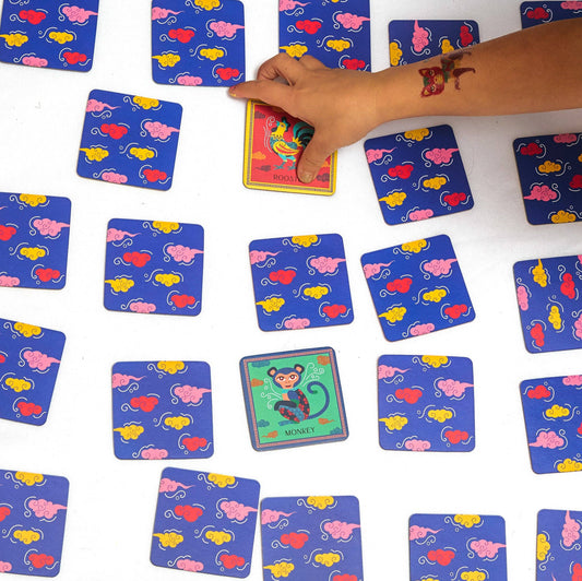 Colorful card game with animal illustrations on blue cards, hand reaching for a card.