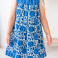 Child wearing a blue floral dress on a white background