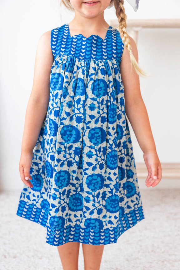 Child wearing a blue floral dress on a white background