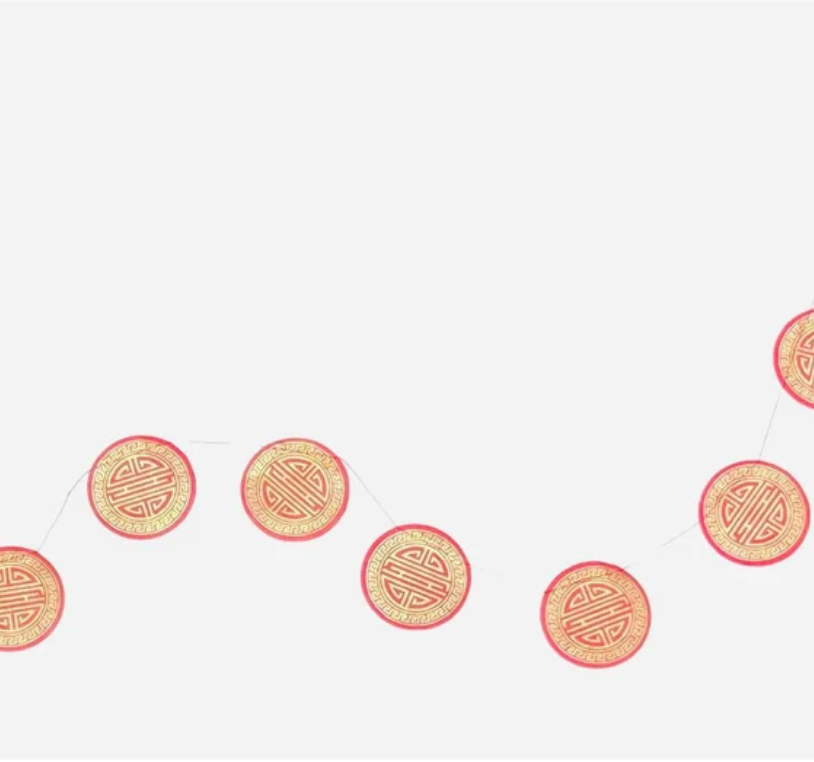 Decorative string of red and gold circular ornaments on a white background