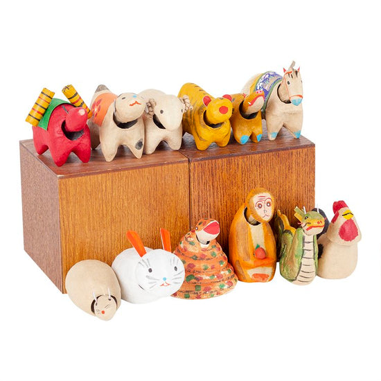Collection of colorful Lunar New Year animal figurines on a wooden base