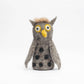Stuffed owl toy with black spots on a white background