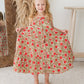 Young girl wearing a floral dress with red flowers in a home setting