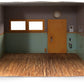 Cardboard model of a room with walls, door, windows, and clock.