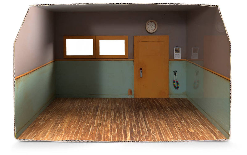 Cardboard model of a room with walls, door, windows, and clock.