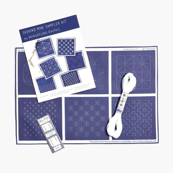 Sashiko mini sampler kit with patterns and a spoon on a white background