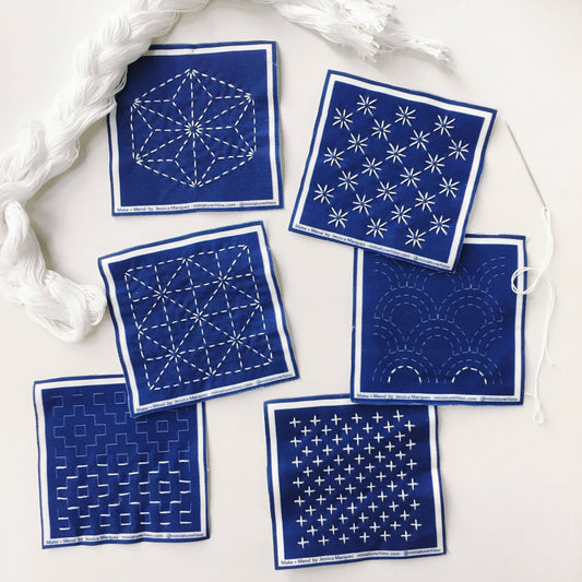 Set of blue bandanas with white patterns on a white surface