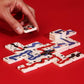 Hand placing a domino piece on a red background