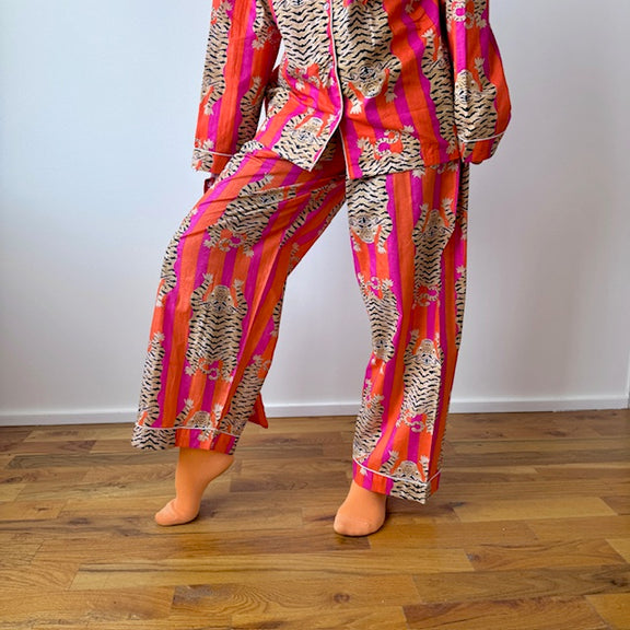 Person wearing a colorful patterned outfit on a wooden floor.