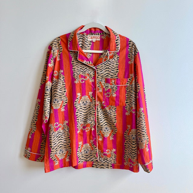 Colorful patterned shirt on a hanger against a white background