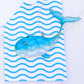 Blue fish on a white and blue striped towel with a white background
