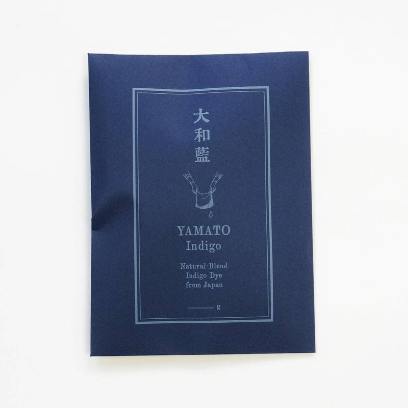 A dark indigo blue fabric packet with white printed text and a simple graphic, labeled 'YAMATO Indigo' and 'Natural Indigo Dye From Japan,' photographed on a clean white background.