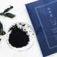 Yamato Indigo product with dried indigo leaves on a white background