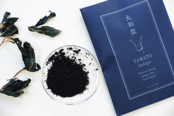 Yamato Indigo product with dried indigo leaves on a white background