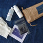 Cosmetic products including bottles, gloves, and a pouch on a blue denim background