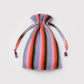 Multicolored striped drawstring bag on a light gray background