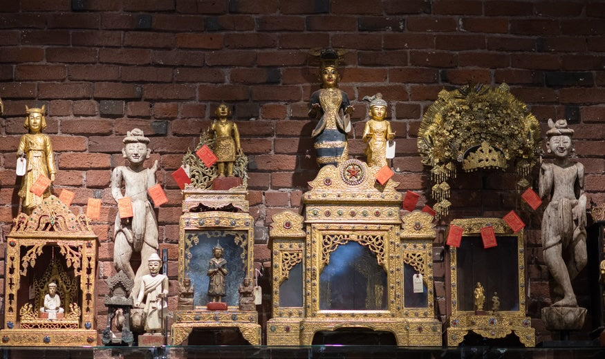 A series of gold and stone statues against a wall