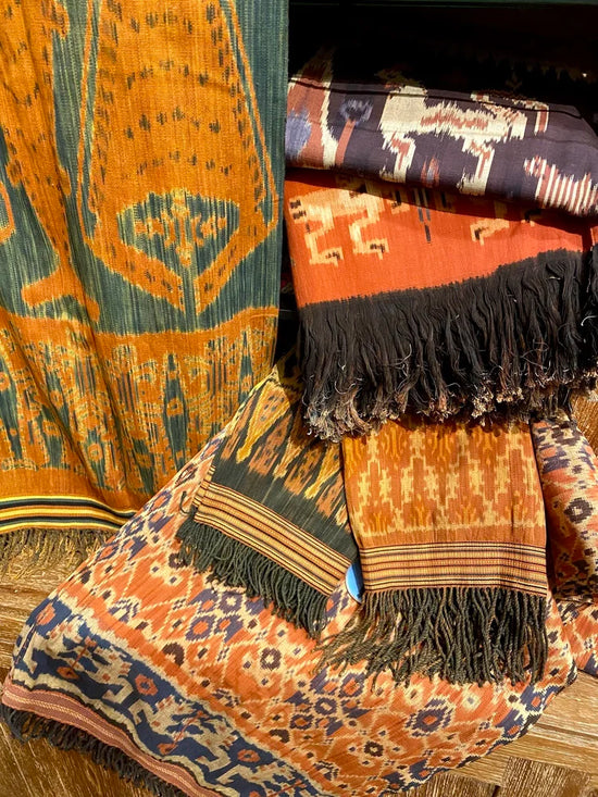 Collection of patterned fabrics with fringes on a wooden surface