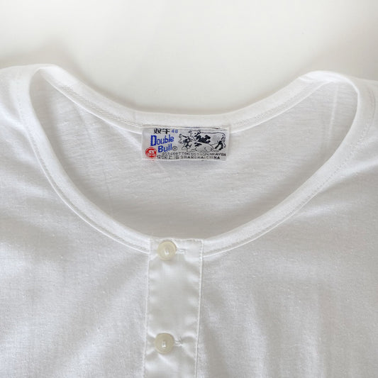 Close-up of a white shirt with a brand label on a light background