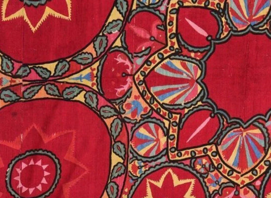 Close-up of a vibrant, multicolored fabric pattern with red as the dominant color.