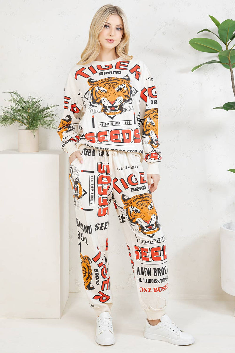 Woman wearing a tiger-themed outfit with brand logos in a minimal indoor setting.